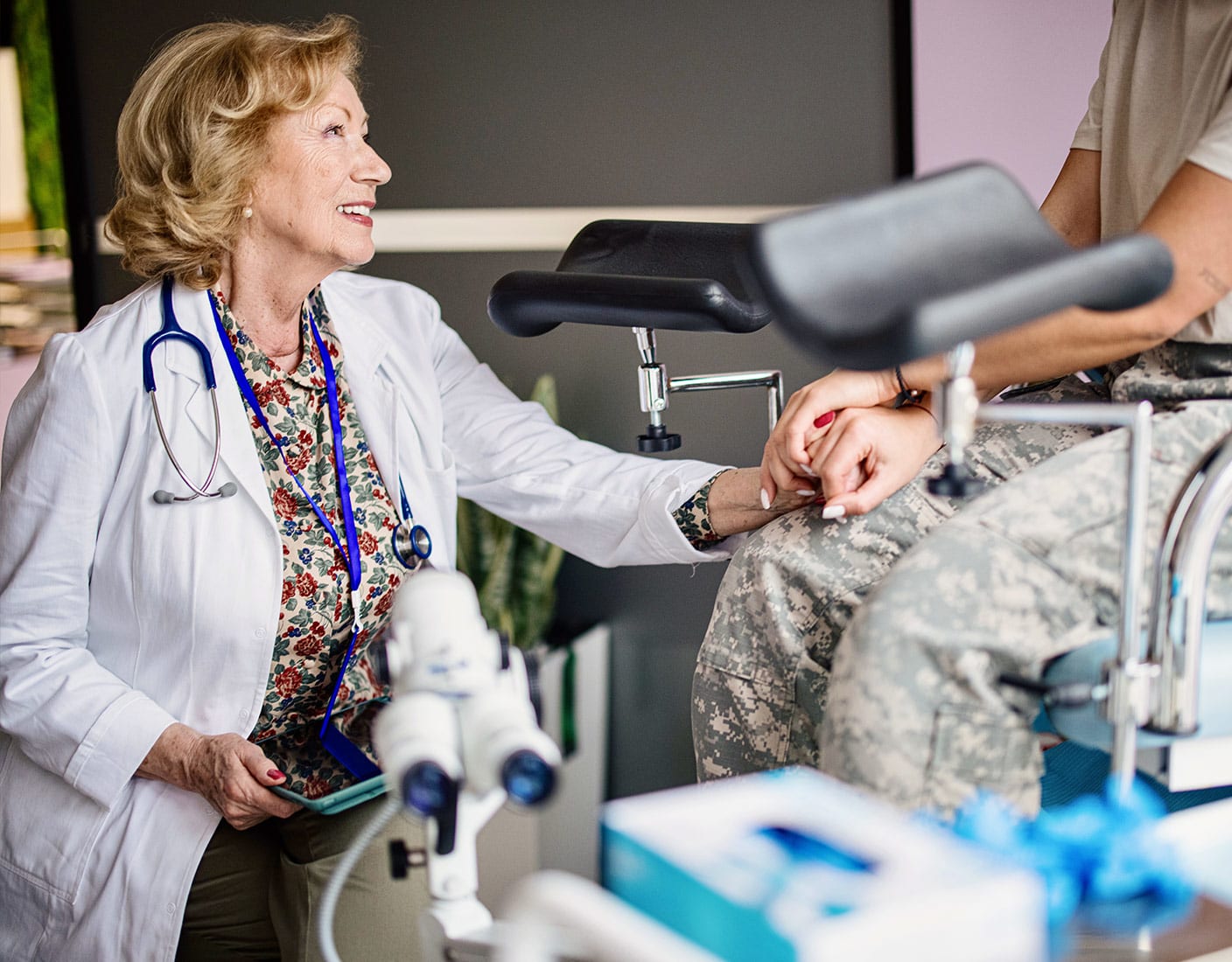 Healthcare professional attending to a patient in military uniform.